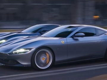 Een grijze Ferrari Roma-sportwagen die op de weg rijdt met een bewegingsonscherpte-effect.