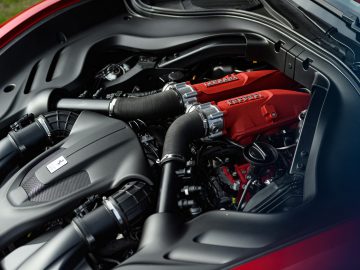 Close-up van een Ferrari Roma-motorruimte met rode accenten.