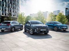 Drie bestverkochte modellen Kia Niro voertuigen tentoongesteld in een moderne stedelijke setting.