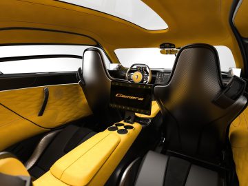 Binnenaanzicht van de Koenigsegg Gemera met gele bekleding en zwarte accenten.