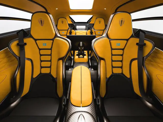 Luxe zwart-geel Koenigsegg Gemera-interieur met vier racestoelen en moderne designelementen.