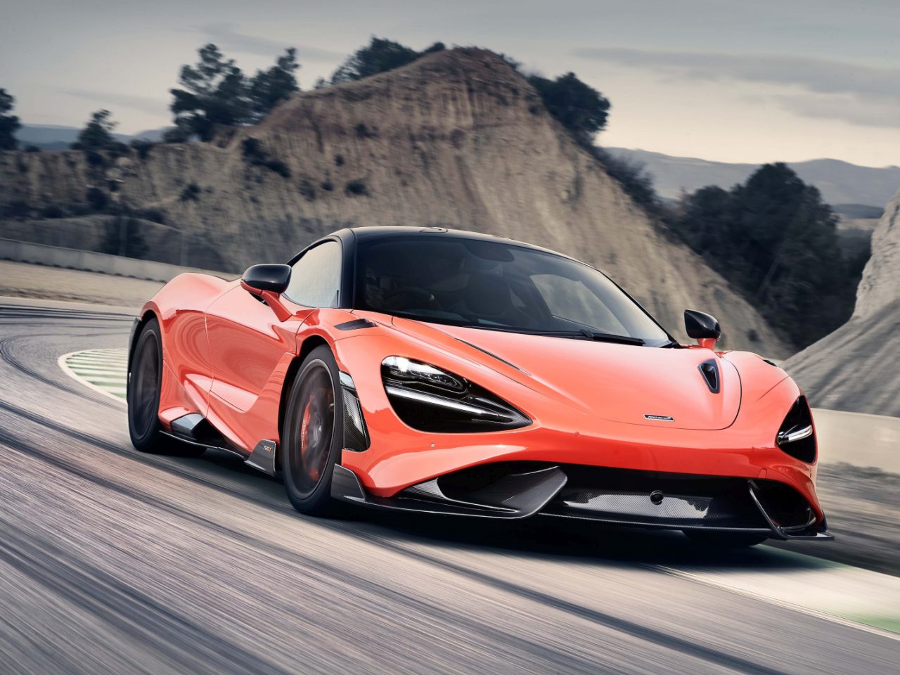 Een McLaren 765LT-sportwagen die met hoge snelheid over een racecircuit rijdt.