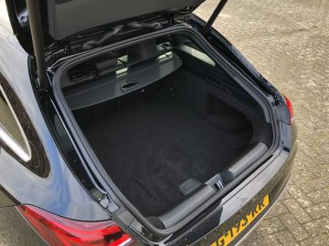 Een open kofferbak van een Mercedes-Benz CLA, met een ruime en lege laadruimte.