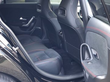 Mercedes-Benz CLA met zwart auto-interieur met lederen stoelen met rode stiksels.