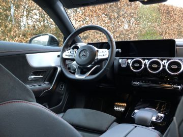 Binnenaanzicht van een Mercedes-Benz CLA-voertuig met het stuur, het dashboard en de middenconsole.