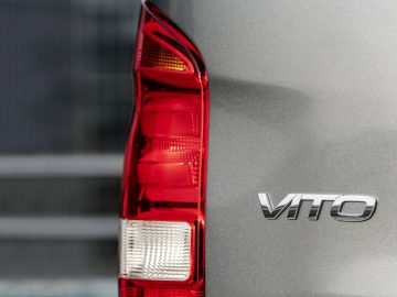 Close-up van het achterlicht en het "vito"-embleem van een Mercedes-Benz Vito op een metalen oppervlak.