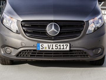 Vooraanzicht van een grijze Mercedes-Benz Vito met de grille, het embleem en de Europese kentekenplaat.