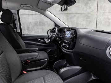 Modern Mercedes-Benz Vito-interieur met de bestuurdersstoel, het dashboard en het stuur met een geïntegreerd infotainmentsysteem.