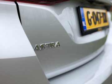 Close-up van een zilveren Opel Astra Sports Tourer met de nadruk op het modelbadge.