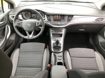 Binnenaanzicht van de Opel Astra Sports Tourer met het stuur, het dashboard, de middenconsole en de stoelen.