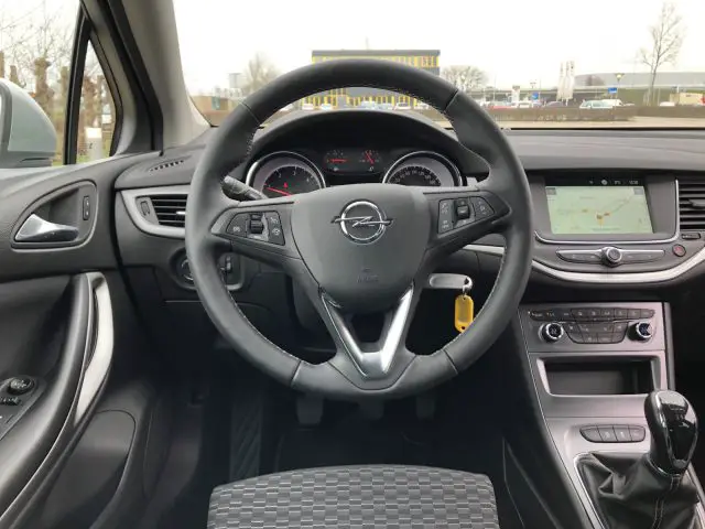 Bestuurdersaanzicht in een moderne Opel Astra Sports Tourer, met het stuur, het dashboard en het infotainmentsysteem.