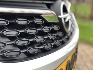 Close-up van het zeshoekige grille-ontwerp van een Opel Astra Sports Tourer met een onscherpe achtergrond.