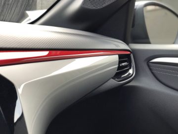 Close-up van het interieur van een Opel Corsa-auto, waarbij de nadruk ligt op de deurgreep en bekleding.