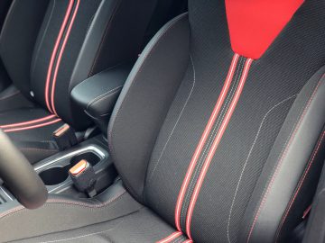 Opel Corsa zwarte autostoelen met rood stikseldetail.
