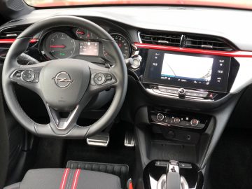 Modern auto-interieur met een stuur met het Opel Corsa-logo, een digitaal dashboard en een centraal infotainmentsysteem.