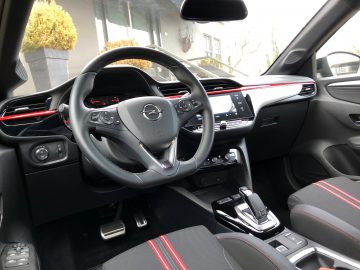 Binnenaanzicht van een Opel Corsa met het stuur, het dashboard en de middenconsole met technologische bedieningselementen.