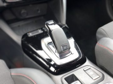 Automatische versnellingspook in een moderne Opel Corsa-cabine.