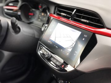 Binnenaanzicht van een Opel Corsa, gericht op het infotainmentsysteem dat navigatie-informatie weergeeft.