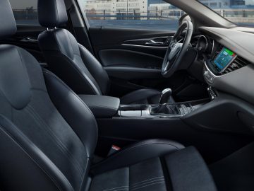 Binnenaanzicht van een Opel Insignia, met de nadruk op de lederen voorstoelen, het dashboard en de middenconsole met touchscreen.
