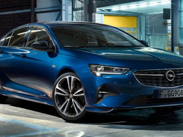 Een blauwe Opel Insignia geparkeerd in een slecht verlichte garage, die het moderne design en de strakke lijnen benadrukt.
