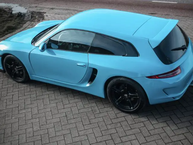 Een blauwe Porsche Boxster geparkeerd op een stenen ondergrond.