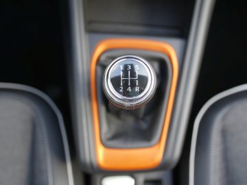 Handgeschakelde zesversnellingsbak in een Renault Captur met oranje bekleding.