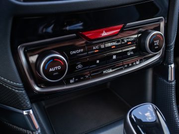 Klimaatbedieningspaneel en versnellingspook in een modern Subaru Forester e-Boxer-interieur.