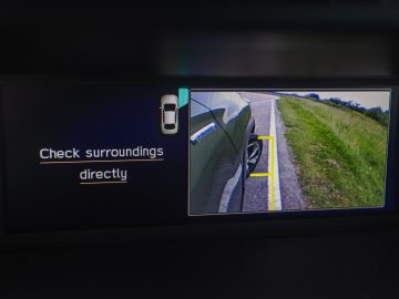 Het dashboarddisplay van een Subaru Forester e-boxer toont een achteruitkijkcamera met richtlijnen voor veilig parkeren.