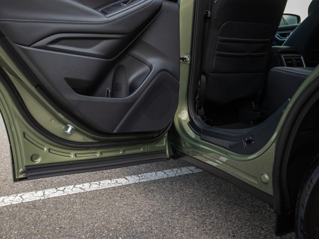 Open autodeur waardoor het interieur en het zijpaneel van een Subaru Forester e-boxer met zwarte bekleding zichtbaar worden.