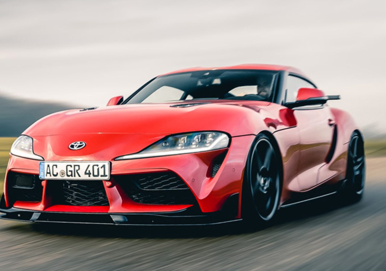 Rode Toyota GR Supra rijdt op een weg met bewegingsonscherpte-effect.