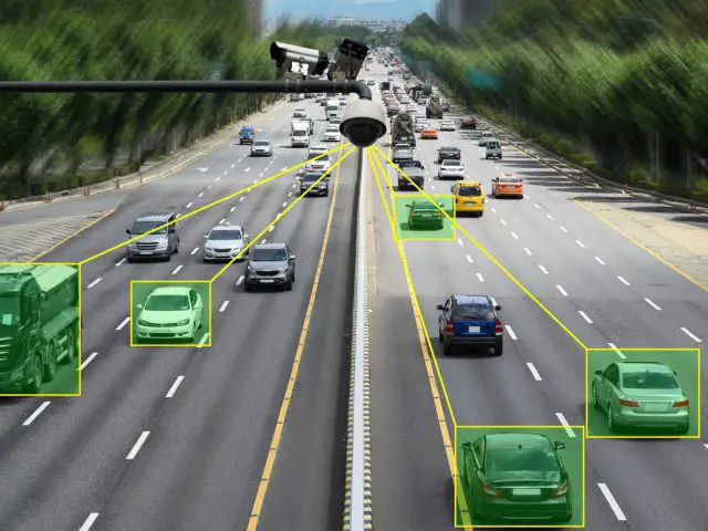De camera van het verkeerstoezichtsysteem houdt voertuigen in de gaten op een snelweg met meerdere rijstroken.