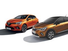 Twee Renault-voertuigen, een Clio en een Captur, in oranje tentoongesteld.