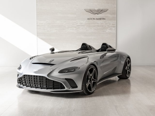 Een slanke Aston Martin V12 Speedster-cabriolet geparkeerd in een schone, moderne showroom.
