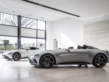 Luxe Aston Martin V12 Speedster-sportwagens tentoongesteld in een moderne showroom.