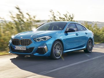 Een blauwe BMW 2 Serie Gran Coupé rijdend op een zonnige weg.