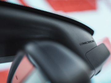 Close-up van de achteruitkijkspiegel van een voertuig met daarop geschreven "Dashcam Nederland Connection".