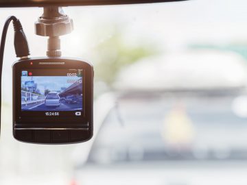 Een Dashcam Nederland gemonteerd op de voorruit van een voertuig registreert de weg voor zich.