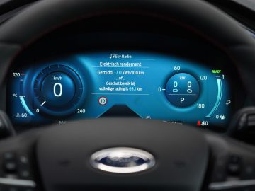 Digitaal dashboard van een Ford Kuga elektrisch voertuig met nulsnelheid, batterijbereik en energie-efficiëntiestatistieken.