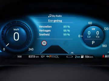 Digitaal dashboard van een Ford Kuga elektrisch voertuig met nulsnelheid, batterijstatus en verschillende indicatoren.