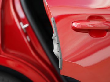 Close-up van de rode autodeurrand van een Ford Kuga met beschermende lijst.