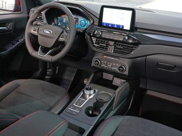 Modern Ford Kuga-interieur met een stuur met digitaal display, infotainmentsysteem en automatische versnellingspook.