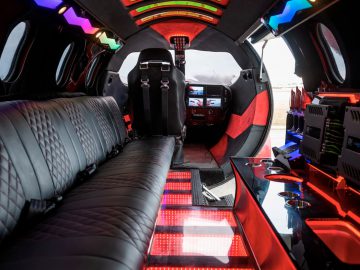 Interieur van een op maat gemaakte limousine met moderne, kleurrijke led-verlichting en luxe zitplaatsen.
