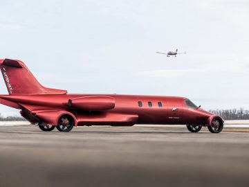 Aangepaste Limo-jet aangepast om op een vliegtuig op een landingsbaan te lijken, met een echt vliegtuig dat op de achtergrond nadert om te landen.