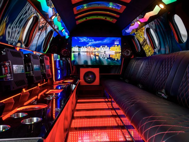Interieur van een luxe limousine met moderne verlichting, comfortabele stoelen en multimedia-entertainmentsysteem.