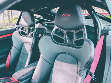 Binnenaanzicht van een Porsche 718 Cayman GT4 met GT4-stoelen en moderne designelementen.