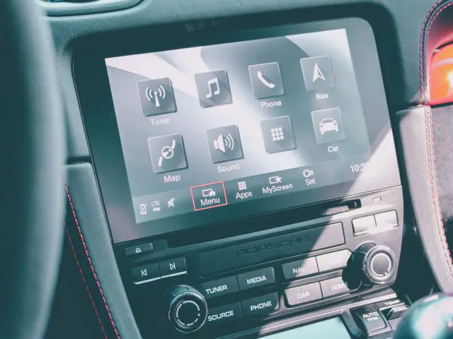Scherm voor infotainmentsysteem in de auto met verschillende opties, zoals navigatie, telefoon en muziek in het interieur van een Porsche 718 Cayman GT4.