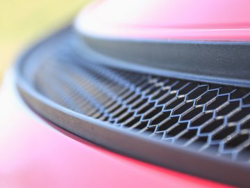 Close-up van de grille van een Porsche 718 Cayman GT4 met de nadruk op het honingraatpatroon.
