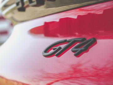 Close-up van een rode Porsche met "gta"-badge op de carrosserie.