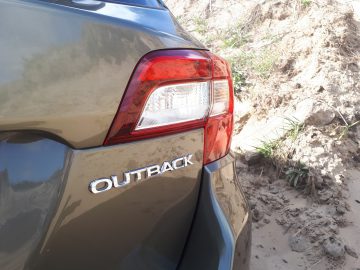 Close-up van de achterhoek van een Subaru Outback, met het achterlicht en het 'Outback'-embleem.