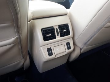 Achterste gedeelte van een Subaru Outback-interieur met twee ventilatieopeningen voor de klimaatregeling en bedieningselementen voor de stoelverwarming.